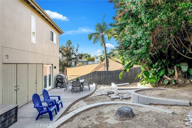 view of patio featuring a deck, outdoor dining space, and fence