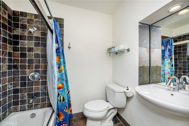 bathroom featuring shower / tub combo, baseboards, a sink, and toilet