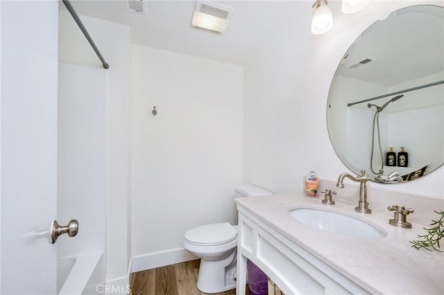 bathroom featuring toilet, visible vents, wood finished floors, and vanity