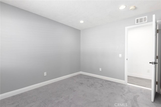 spare room with carpet floors, baseboards, visible vents, and recessed lighting