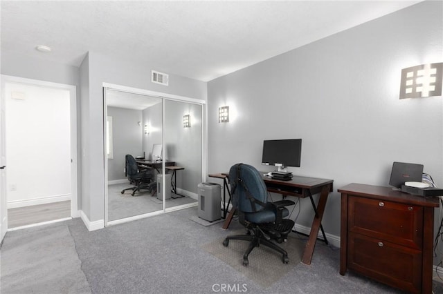 carpeted office space featuring visible vents and baseboards