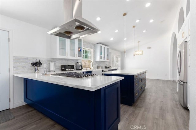 kitchen with island range hood, stainless steel appliances, white cabinets, blue cabinetry, and a center island