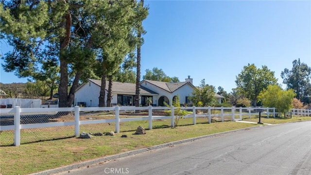 ranch-style house featuring fence and a front lawn