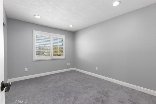 carpeted spare room with a textured ceiling, recessed lighting, and baseboards