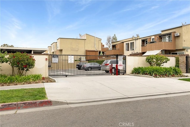 view of front of home featuring fence, a gate, and stucco siding