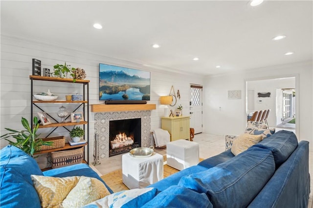 living area with a fireplace, ornamental molding, and recessed lighting