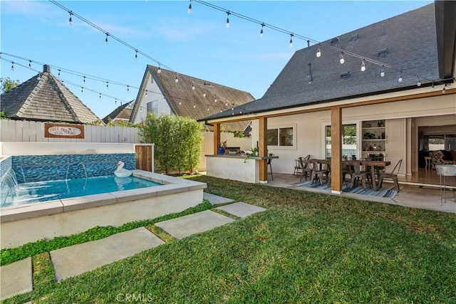 view of pool with a fenced backyard, outdoor dry bar, a lawn, a swimming pool, and a patio area