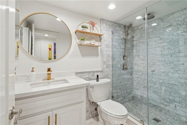 full bath with tile walls, recessed lighting, toilet, a stall shower, and vanity