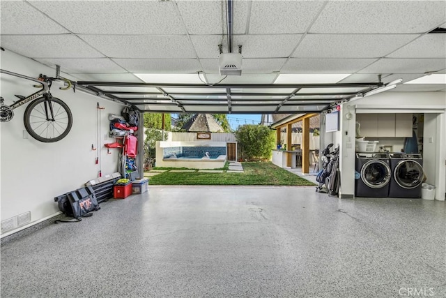 garage with washing machine and dryer and visible vents