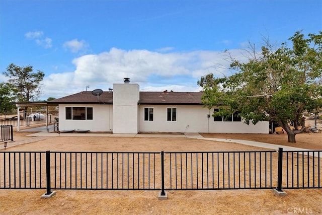 58676 Sunflower Dr, Yucca Valley, CA 92284 - rear view of property featuring stucco siding, a patio, and a chimney