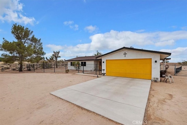 58676 Sunflower Dr, Yucca Valley, CA 92284 - ranch-style home with an attached garage, concrete driveway, stucco siding, and a gate