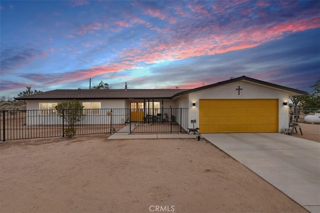 ranch-style home with a garage, fence, driveway, and stucco siding