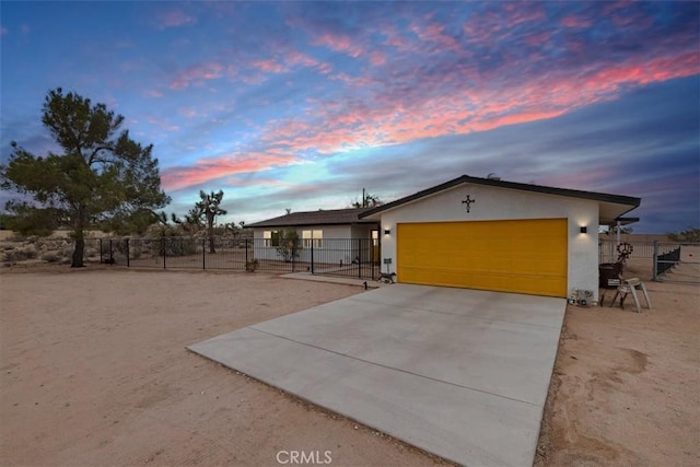 view of front of house featuring an attached garage, fence, concrete driveway, a gate, and stucco siding