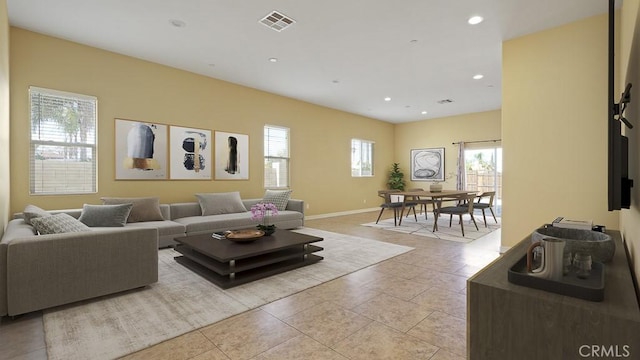 living room featuring a healthy amount of sunlight, light tile patterned floors, visible vents, and recessed lighting