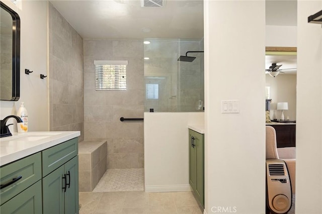 full bathroom featuring tile patterned flooring, ceiling fan, vanity, and walk in shower