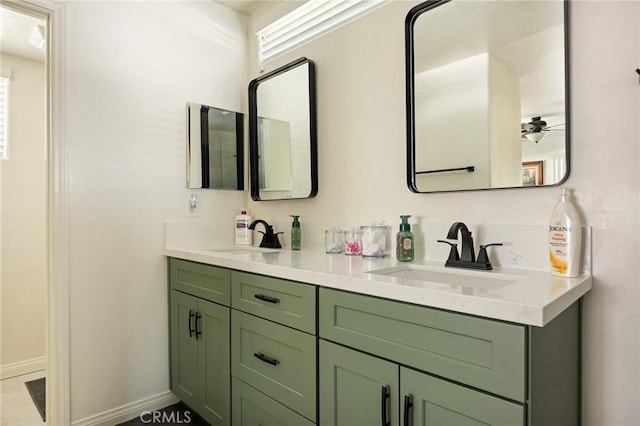 full bathroom featuring ceiling fan, double vanity, a sink, and baseboards