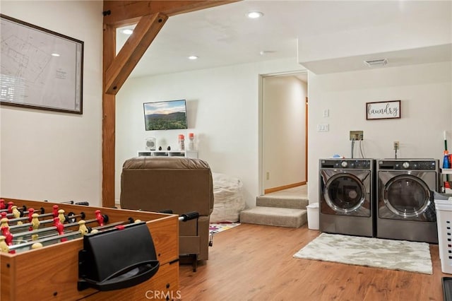 laundry room featuring wood finished floors, washing machine and dryer, visible vents, and recessed lighting