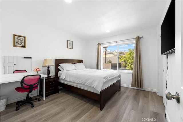 bedroom featuring baseboards and wood finished floors