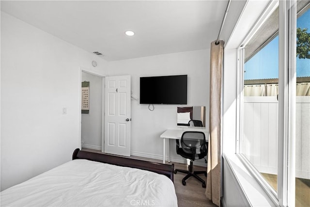 bedroom with baseboards, wood finished floors, and recessed lighting