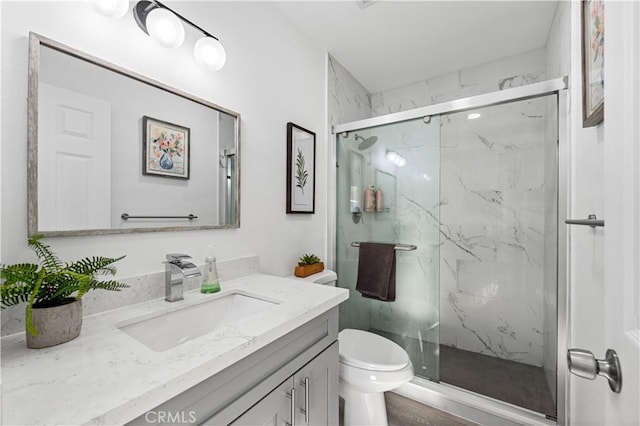 bathroom featuring vanity, a marble finish shower, and toilet