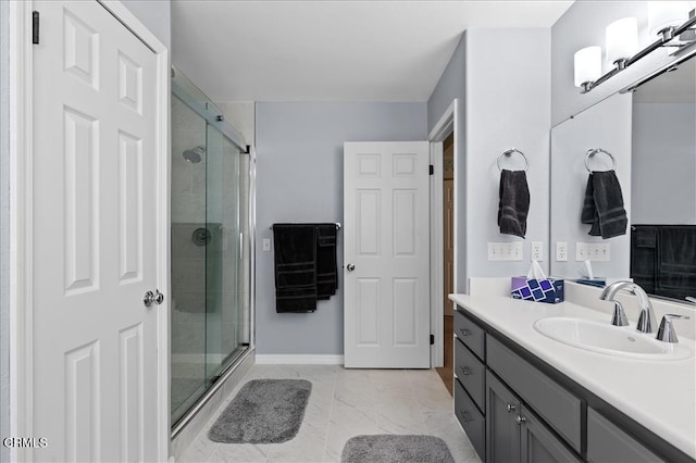 bathroom featuring marble finish floor, a stall shower, vanity, and baseboards