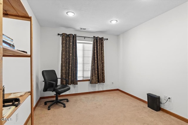 home office with light carpet, visible vents, and baseboards