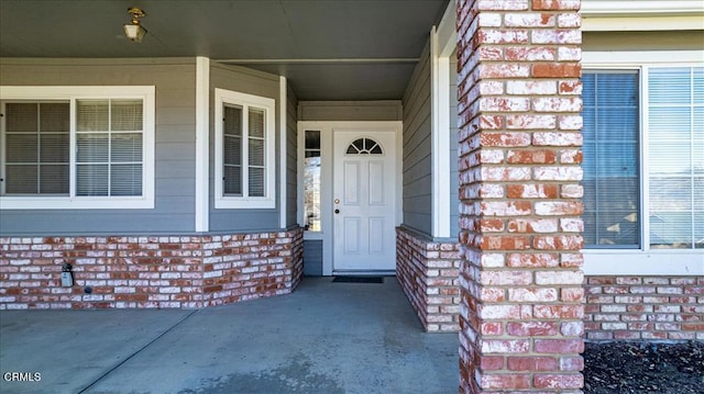 property entrance featuring brick siding