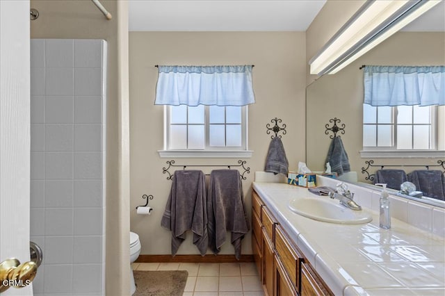 bathroom featuring tile patterned flooring, vanity, toilet, and walk in shower