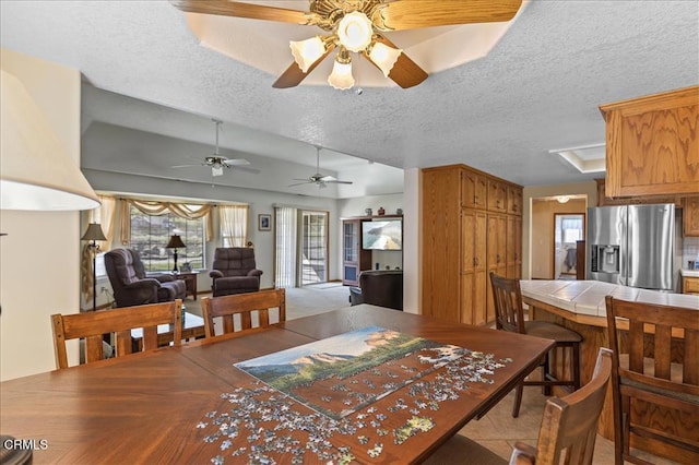 dining area featuring vaulted ceiling and a textured ceiling