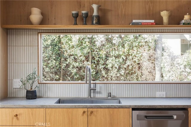 kitchen with plenty of natural light, light countertops, dishwasher, and a sink