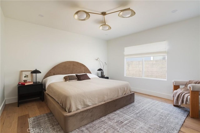 bedroom with baseboards and wood finished floors