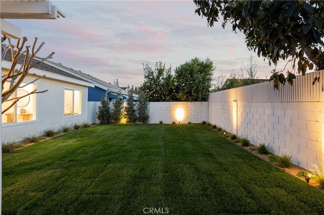 yard at dusk with a fenced backyard