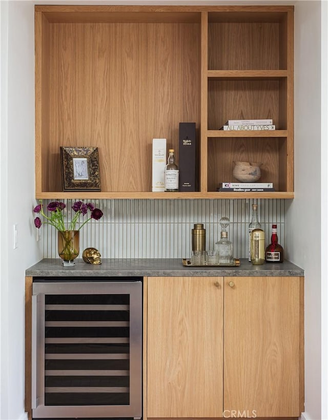 bar featuring beverage cooler, a dry bar, and backsplash