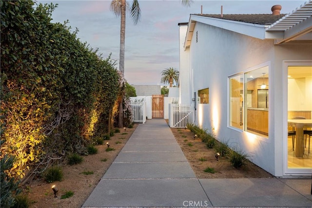 view of home's exterior featuring fence, a gate, and stucco siding