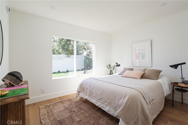 bedroom with baseboards and wood finished floors