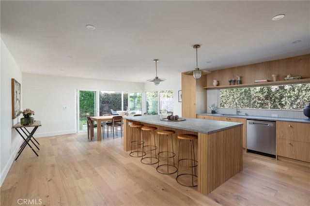 kitchen featuring a kitchen island, dishwasher, light wood finished floors, and modern cabinets