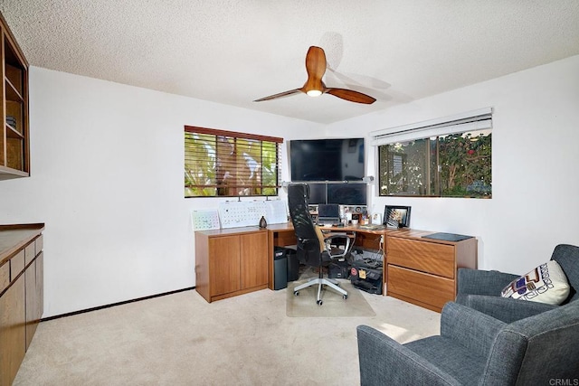 carpeted office featuring a ceiling fan, a textured ceiling, and baseboards