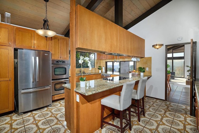 kitchen featuring stainless steel appliances, light tile patterned flooring, beam ceiling, and brown cabinets