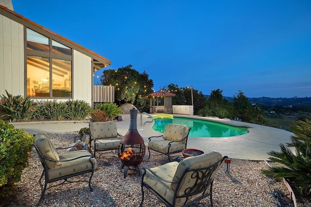 outdoor pool featuring an outdoor fire pit, a patio area, and fence