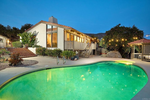 outdoor pool with a patio area, stairway, and a gazebo