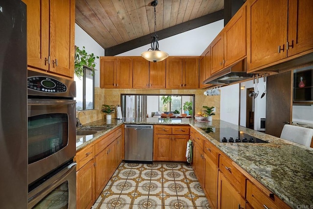 kitchen featuring under cabinet range hood, stainless steel appliances, a sink, vaulted ceiling, and brown cabinets