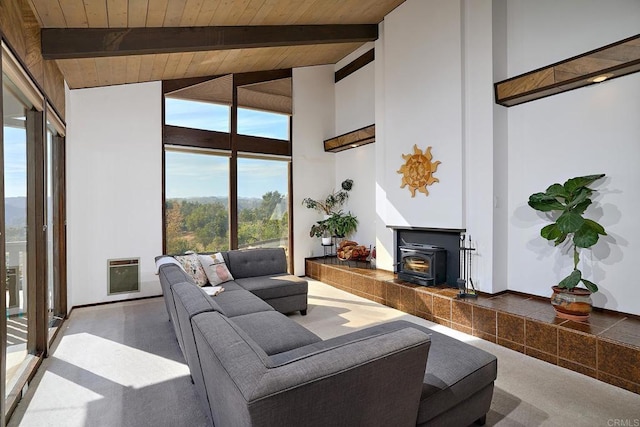 carpeted living area featuring a wood stove, heating unit, wooden ceiling, and beamed ceiling