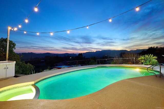 41850 Via Del Gavilan, Fallbrook, CA 92028 - pool at dusk with a pool with connected hot tub, a mountain view, and a patio area