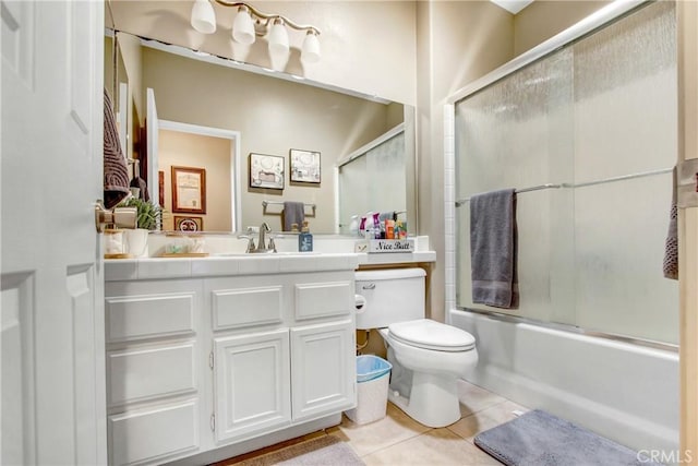 full bathroom with toilet, tile patterned flooring, combined bath / shower with glass door, and vanity