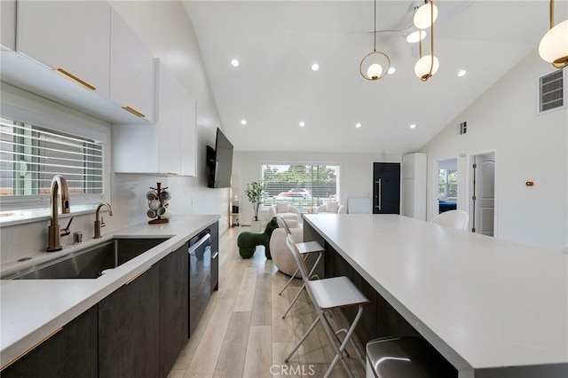 kitchen featuring light wood-type flooring, light countertops, a sink, and white cabinetry