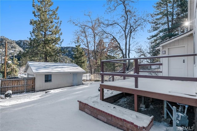 snow covered deck with fence and an outdoor structure