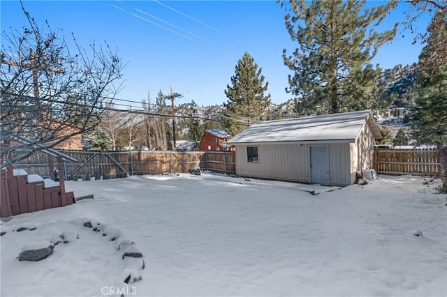 1131 Apple Ave, Wrightwood, CA 92397 - snowy yard with a fenced backyard, a storage unit, and an outbuilding
