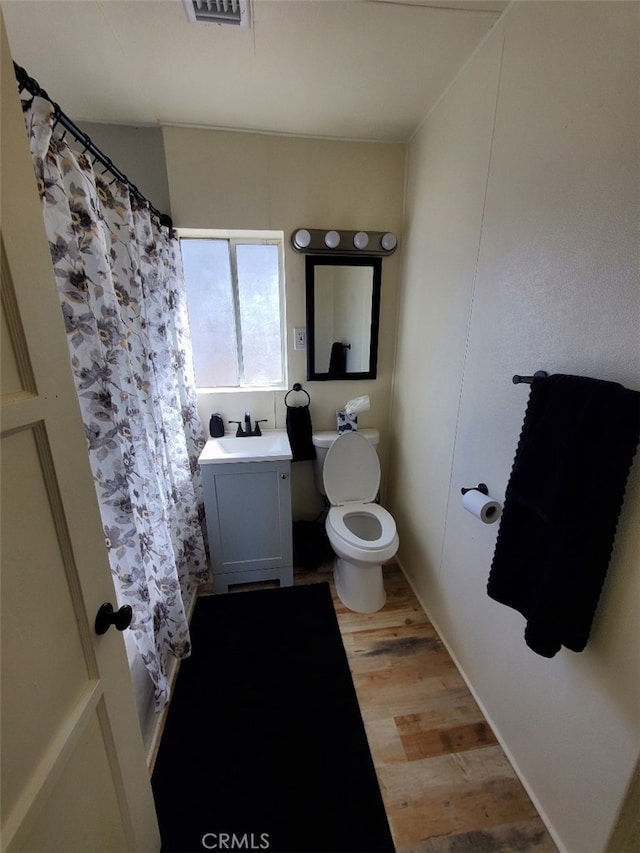 full bath with toilet, wood finished floors, vanity, and a shower with curtain