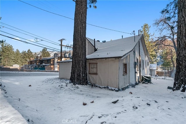 view of snow covered exterior featuring fence