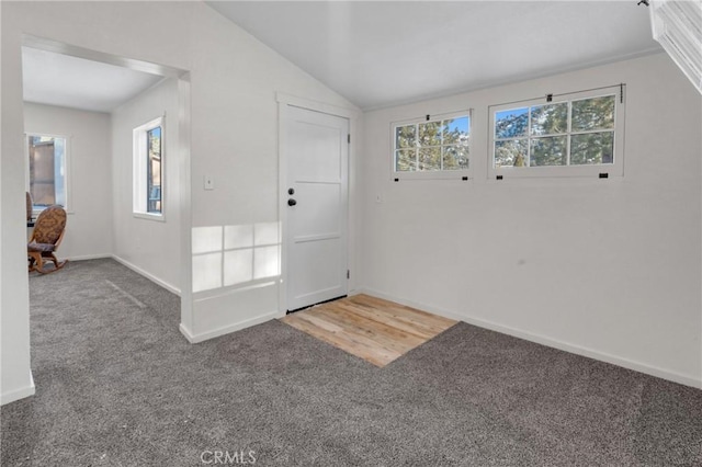 carpeted entryway featuring plenty of natural light, baseboards, and vaulted ceiling